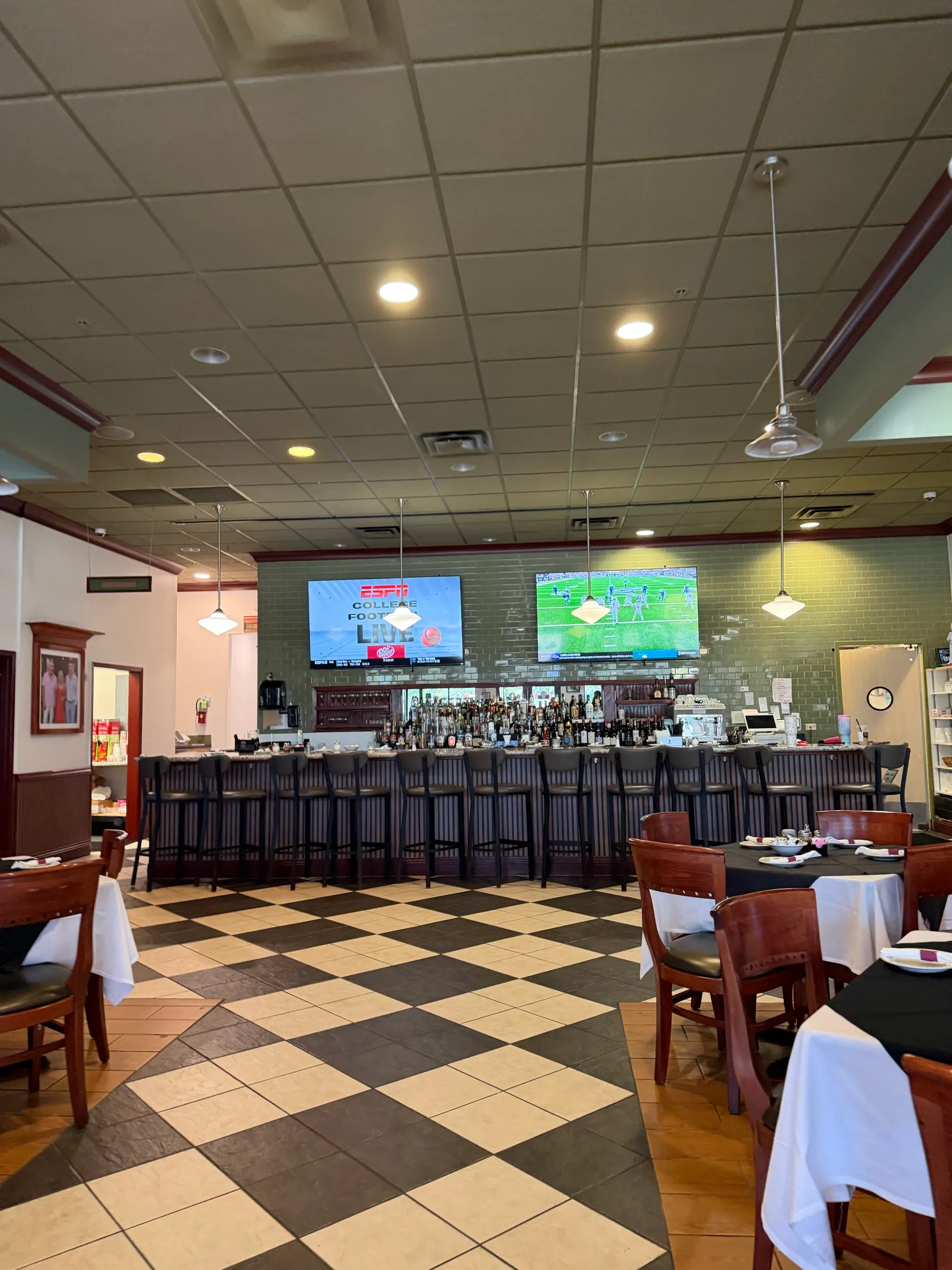Full bar, set tables, and TVs in the dining room at Joe's